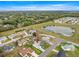 A stunning aerial shot showcasing a home near a tranquil pond, surrounded by lush greenery and neighboring houses at 9661 Se 173Rd Pl, Summerfield, FL 34491