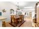 Dining area featuring laminate flooring, a chandelier, and open access to the kitchen and living room at 9661 Se 173Rd Pl, Summerfield, FL 34491