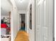 Hallway features white walls, wood-look floors and white doors at 9661 Se 173Rd Pl, Summerfield, FL 34491