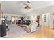 Inviting living room featuring plush carpeting, ceiling fan, and an abundance of natural light at 9661 Se 173Rd Pl, Summerfield, FL 34491