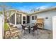 Cozy patio area with a table and chairs next to a screened in porch at 9661 Se 173Rd Pl, Summerfield, FL 34491