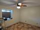 Modest bedroom with tiled floors, ceiling fan, small window, and neutral walls at 10831 Se 50Th Ter, Belleview, FL 34420