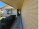 A covered front porch, leading to the front door, with a painted brick exterior at 10831 Se 50Th Ter, Belleview, FL 34420