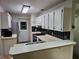 A well-lit kitchen with black and white backsplash, white cabinets, and matching appliances at 10831 Se 50Th Ter, Belleview, FL 34420