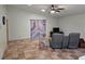 The living room with tile floors, a ceiling fan, and large curtain-covered window at 10831 Se 50Th Ter, Belleview, FL 34420