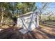 Backyard view of a white shed on a grassy lawn with a small window and secure locking mechanism at 1126 Ne 34Th Ave, Ocala, FL 34470