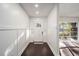 Well-lit hallway with white walls, dark wood floors, and a charming front door at 1126 Ne 34Th Ave, Ocala, FL 34470