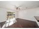 Bright living room with dark wood floors, a ceiling fan, and a large window overlooking the front yard at 1126 Ne 34Th Ave, Ocala, FL 34470