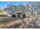 A cozy home featuring a minimalist backyard deck, set against a backdrop of lush trees at 1126 Ne 34Th Ave, Ocala, FL 34470