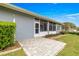 Outdoor patio area with brick pavers, adjacent to a lush green yard, and large windows at 11593 Sw 75Th Cir, Ocala, FL 34476