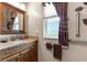 Bathroom featuring a wood vanity with granite countertop and a decorative window curtain at 11593 Sw 75Th Cir, Ocala, FL 34476