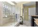 Bathroom featuring glass shower, tiled shower with glass block window, and a seat at 11593 Sw 75Th Cir, Ocala, FL 34476