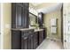 Bathroom featuring glass shower, dark wood cabinets, granite countertop, and tile floors at 11593 Sw 75Th Cir, Ocala, FL 34476