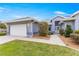 Beautiful home exterior showcasing well-kept lawn, gray paint, paver driveway, and manicured landscaping at 11593 Sw 75Th Cir, Ocala, FL 34476