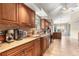 This kitchen features granite counters, wood cabinetry, stainless appliances, and tiled flooring at 11593 Sw 75Th Cir, Ocala, FL 34476