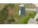 Aerial view of house with a black roof, kayaks, and green lawn with fencing at 11684 Sw 56Th Ter, Ocala, FL 34476