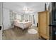 Well-lit bedroom featuring a plush bed, carpet flooring, a ceiling fan and a vintage cabinet at 11684 Sw 56Th Ter, Ocala, FL 34476