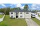 Two-story home with an attached garage, lush front lawn, and long driveway, captured from an aerial perspective at 11684 Sw 56Th Ter, Ocala, FL 34476