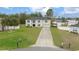 A front exterior view of the two-story home, showcasing the manicured lawn and long private driveway at 11684 Sw 56Th Ter, Ocala, FL 34476