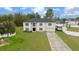 Front exterior of a two-story home with manicured lawn, long driveway, and an attached two-car garage at 11684 Sw 56Th Ter, Ocala, FL 34476