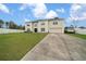 Two-story traditional home featuring a manicured lawn and an oversized driveway at 11684 Sw 56Th Ter, Ocala, FL 34476