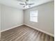 Bright bedroom featuring wood flooring, a ceiling fan, and a window, creating a cozy and inviting space at 12461 Se 126Th Ct, Ocklawaha, FL 32179