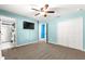 Carpeted bedroom with ceiling fan, TV, closet and ensuite bathroom at 13 Pine Course Radl, Ocala, FL 34472