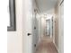 Clean and well-lit hallway showcasing wood floors and multiple doors leading to various rooms in the home at 13 Pine Course Radl, Ocala, FL 34472