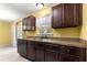 Functional kitchen featuring dark wood cabinets, a stainless steel sink, and plenty of counter space for meal preparation at 13 Pine Course Radl, Ocala, FL 34472