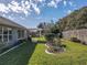 Manicured backyard featuring lush green lawn, garden beds, a pergola, and mature trees at 13340 Se 86Th Cir, Summerfield, FL 34491