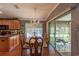 Dining room with elegant chandelier, wood table and chairs, and glass sliding doors at 13340 Se 86Th Cir, Summerfield, FL 34491