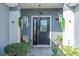 Inviting front entrance with a decorative door and sidelight, enhanced by potted plants at 13340 Se 86Th Cir, Summerfield, FL 34491