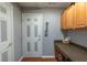 Practical laundry room with storage cabinets, countertop, white door, and wood-look flooring at 13340 Se 86Th Cir, Summerfield, FL 34491