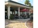 Outdoor dining patio with a stone floor, overhead covering supported by pillars and seating for residents at 13625 Se 93Rd Court Rd, Summerfield, FL 34491