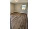 Empty bedroom with neutral walls, window, and wood-look vinyl flooring at 14805 Se 51St Ct, Summerfield, FL 34491