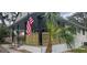 Attractive home with a large porch, American flag, palm tree and beautifully landscaped surroundings at 14805 Se 51St Ct, Summerfield, FL 34491