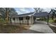 Welcoming single-story home featuring a covered porch with seating and an attached carport at 14805 Se 51St Ct, Summerfield, FL 34491