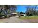 Charming home exterior with a shed, lush trees, and a driveway at 14805 Se 51St Ct, Summerfield, FL 34491