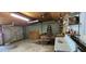 Interior of an outbuilding with a garage door, shelving, work tables, and utility sink at 14805 Se 51St Ct, Summerfield, FL 34491