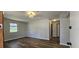 Bright living room with fresh paint, wooden floor and natural light from the window at 14805 Se 51St Ct, Summerfield, FL 34491