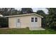 Exterior of the outbuilding, with wood siding, a single door and double doors, sitting on a concrete base at 14805 Se 51St Ct, Summerfield, FL 34491