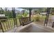 Inviting porch featuring a classic wooden porch swing and decorative iron railings at 14805 Se 51St Ct, Summerfield, FL 34491