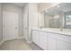 Bright bathroom with double vanity, white cabinetry, quartz countertop, and a large mirror above at 15705 Sw 55Th Avenue Rd, Ocala, FL 34473