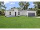 Charming single-story home with gray roof, lush green lawn, and a two-car garage at 15705 Sw 55Th Avenue Rd, Ocala, FL 34473