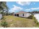 Spacious backyard featuring a lush lawn, white fence, and a covered patio perfect for outdoor entertaining at 3925 Ne 58Th Cir, Silver Springs, FL 34488