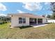 Back of house featuring a covered patio, windows and manicured lawn at 3925 Ne 58Th Cir, Silver Springs, FL 34488