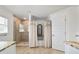 Bright bathroom with a tiled walk-in shower, tub with curtains, white cabinets and granite countertops at 3925 Ne 58Th Cir, Silver Springs, FL 34488