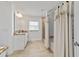 Bright bathroom featuring a large vanity, tub with shower and curtains, tiled floors, and a large window at 3925 Ne 58Th Cir, Silver Springs, FL 34488