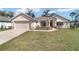 Charming single-story home featuring a manicured lawn, attached two-car garage, and inviting front porch at 3925 Ne 58Th Cir, Silver Springs, FL 34488