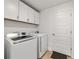 Modern laundry room with white cabinets, tile floor and Samsung washer and dryer at 3925 Ne 58Th Cir, Silver Springs, FL 34488